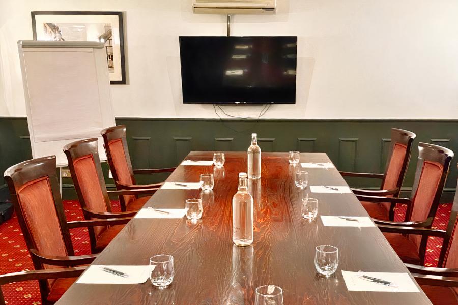 Board Room at Bridge School: polished wooden table, ideal for meetings and presentations.
