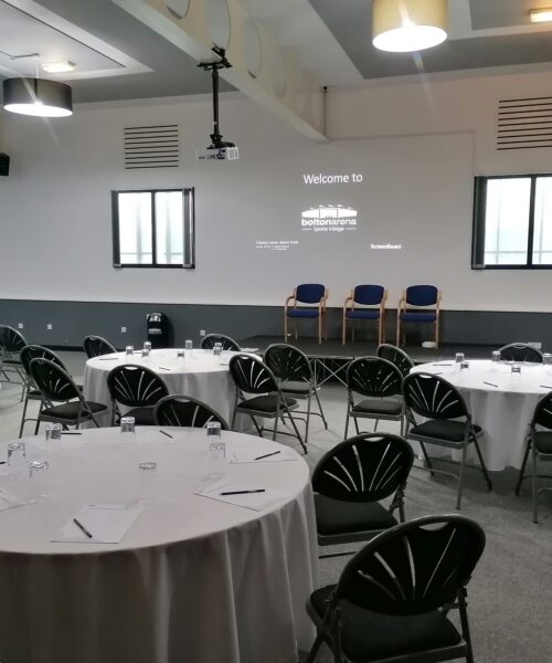 Conference room at Bridge School set for workshop with round tables and natural light.