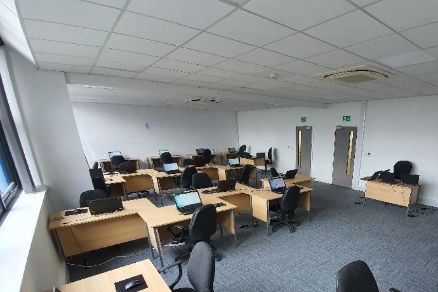 Versatile training room at Bridge School with laptops for corporate workshops.