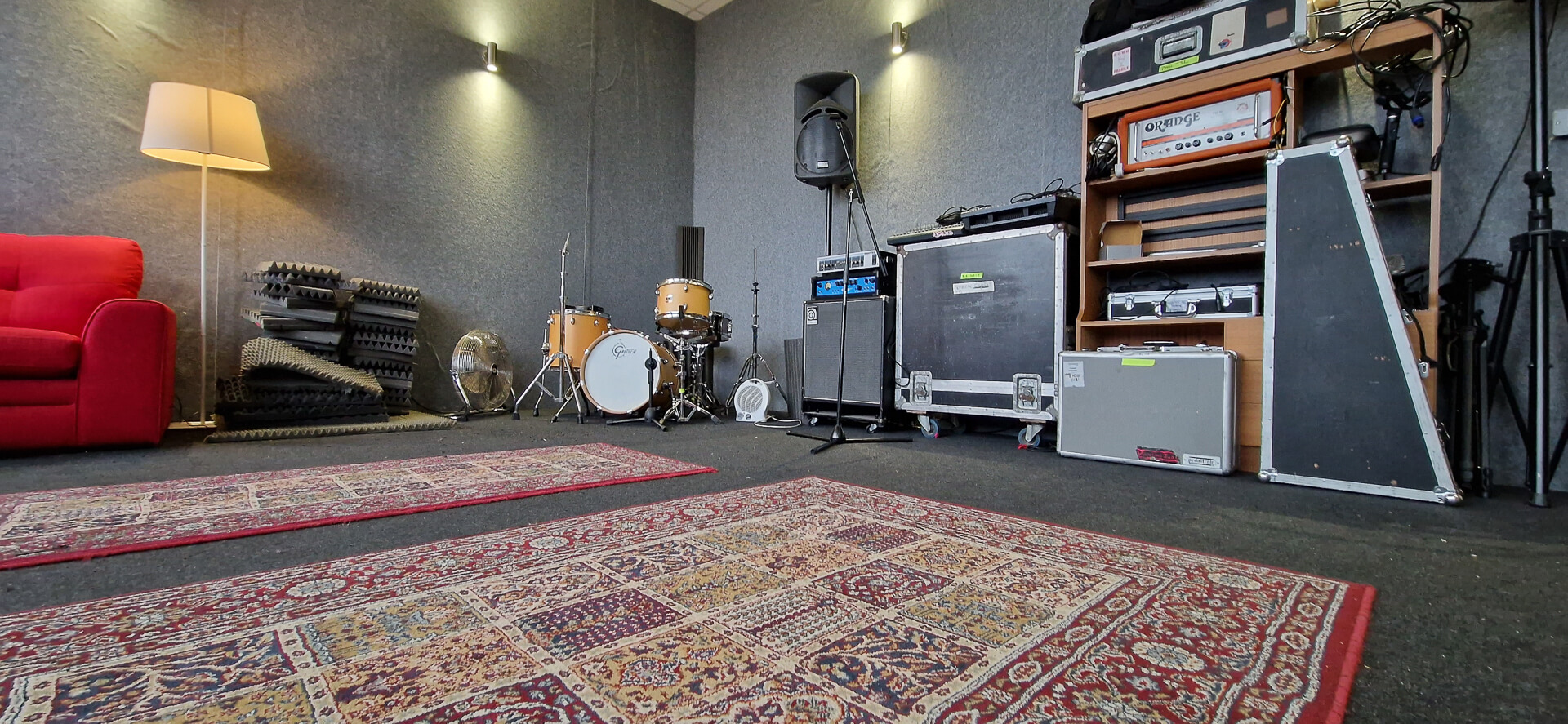 Versatile rehearsal space with sound equipment for live performances and meetings.