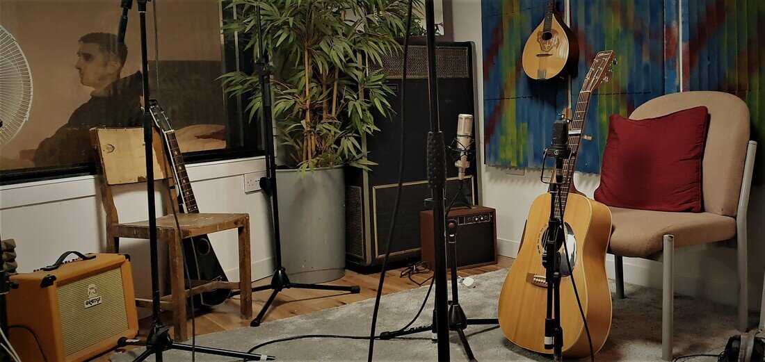Cozy recording studio with instruments, ideal for music workshops and intimate events.