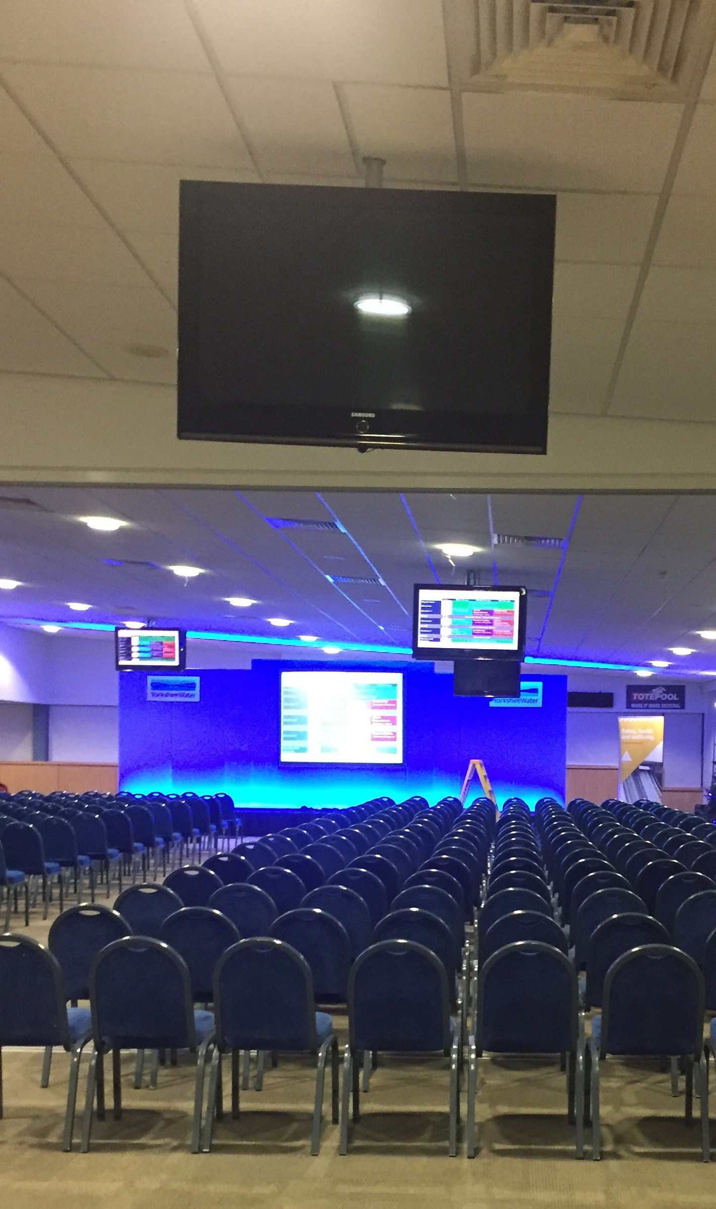 Bramham Hall conference space with blue stage backdrop, ideal for events and presentations.