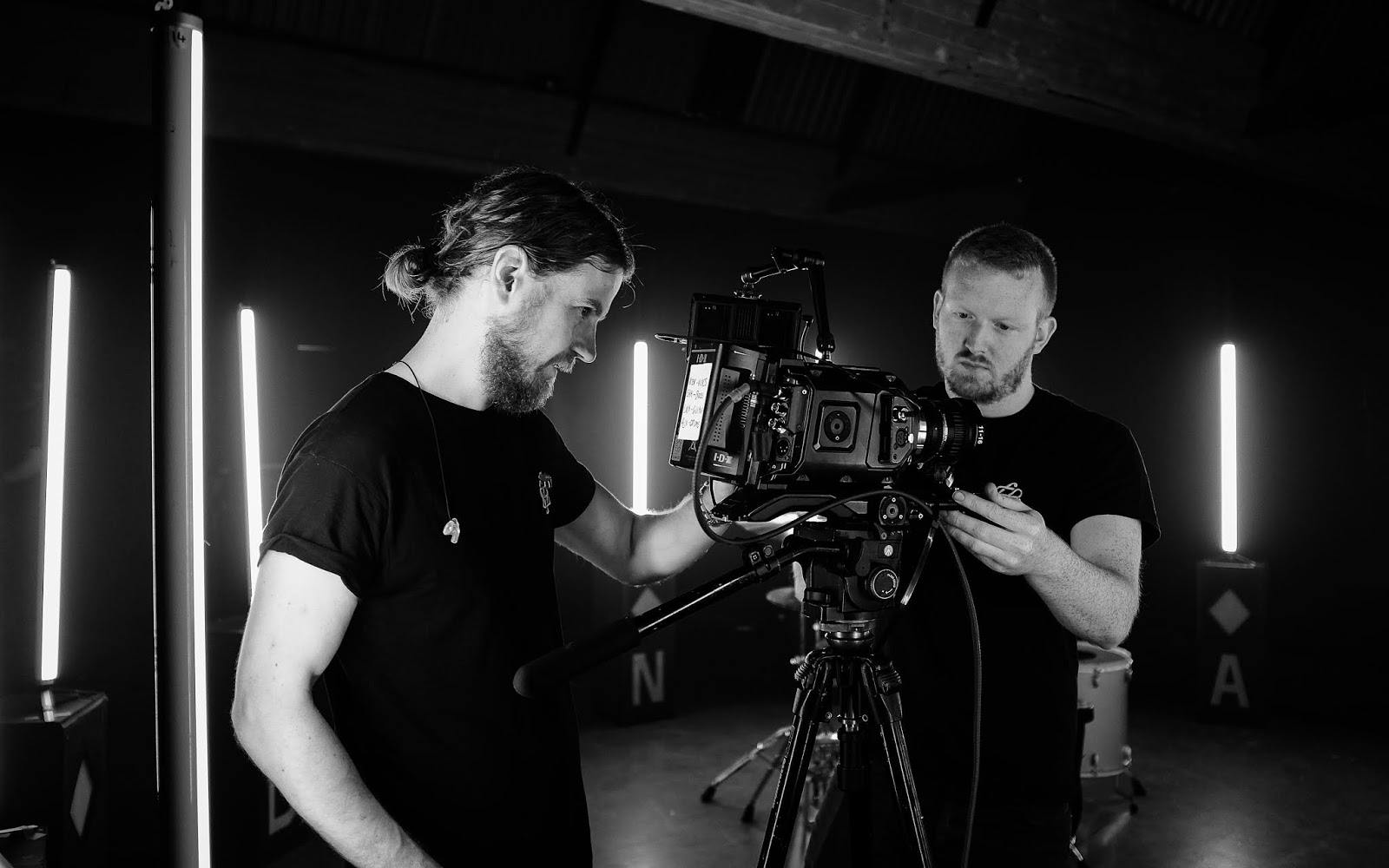 Professionals setting up video equipment at Sitcom Soldiers Studios for a film event.