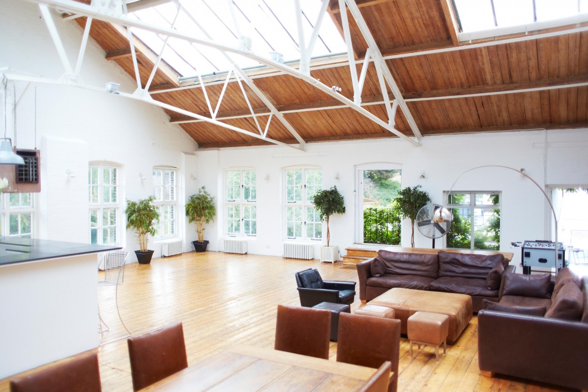 Spacious warehouse studio with high ceiling for meetings and events, ideal for gatherings.