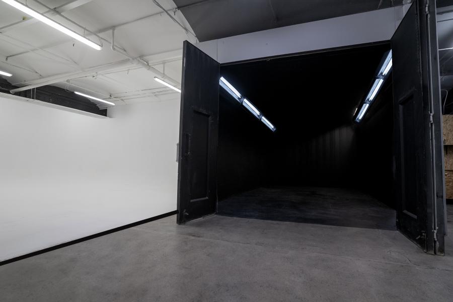 Versatile event space in The Warehouse Studio with white and black backgrounds for presentations.