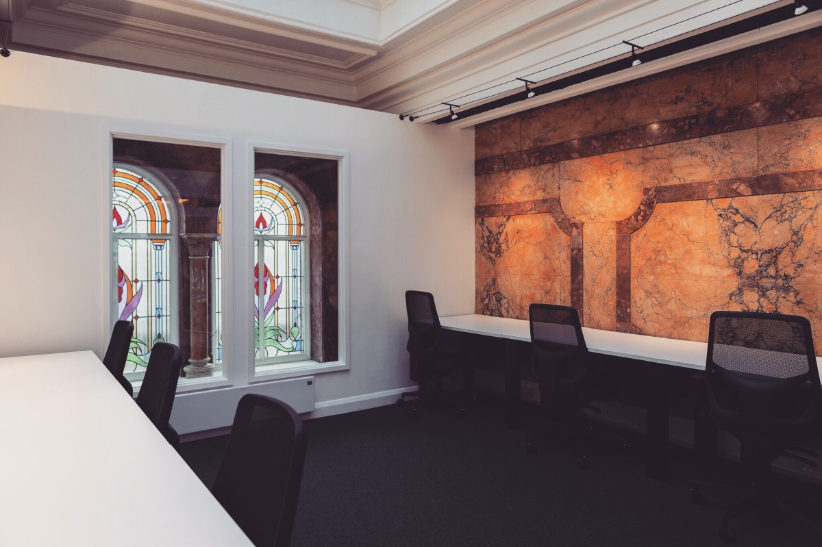 Sophisticated meeting space in Profolk with stained glass and marble, perfect for events.