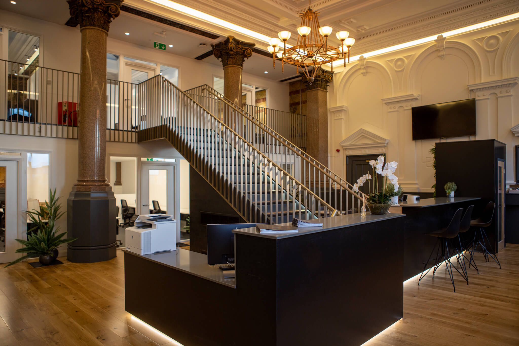 Modern reception area with grand staircase in elegant Profolk venue for events.