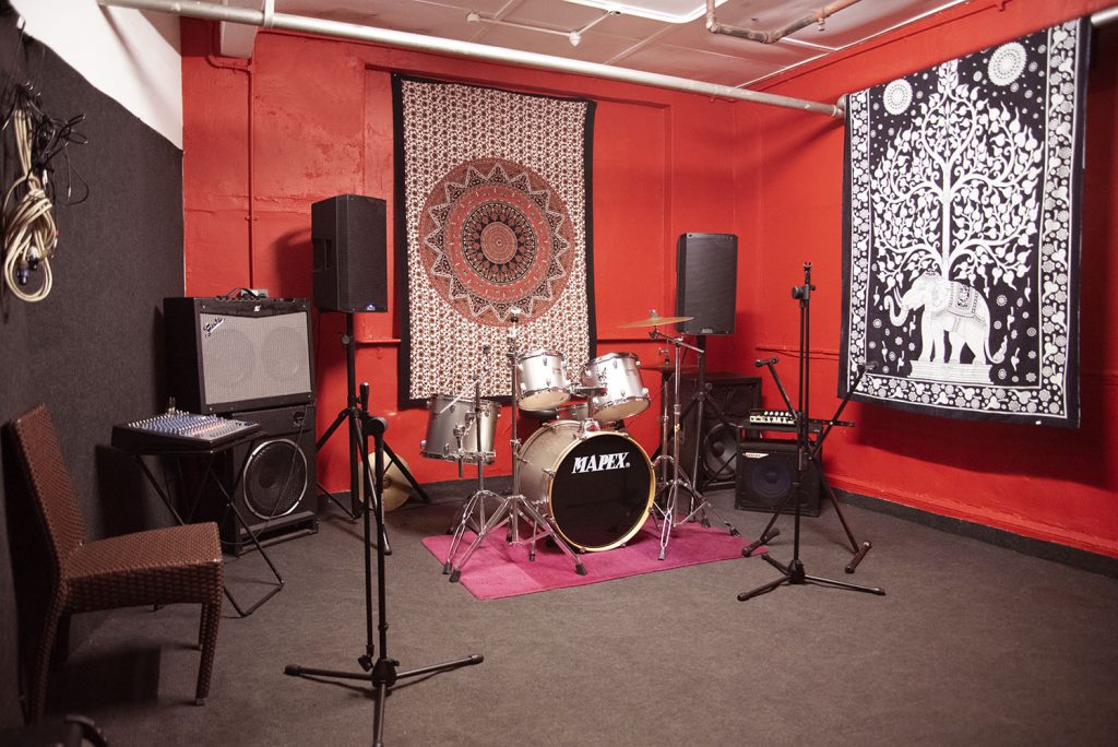 Versatile rehearsal space with drum kit, perfect for creative meetings and live performances.