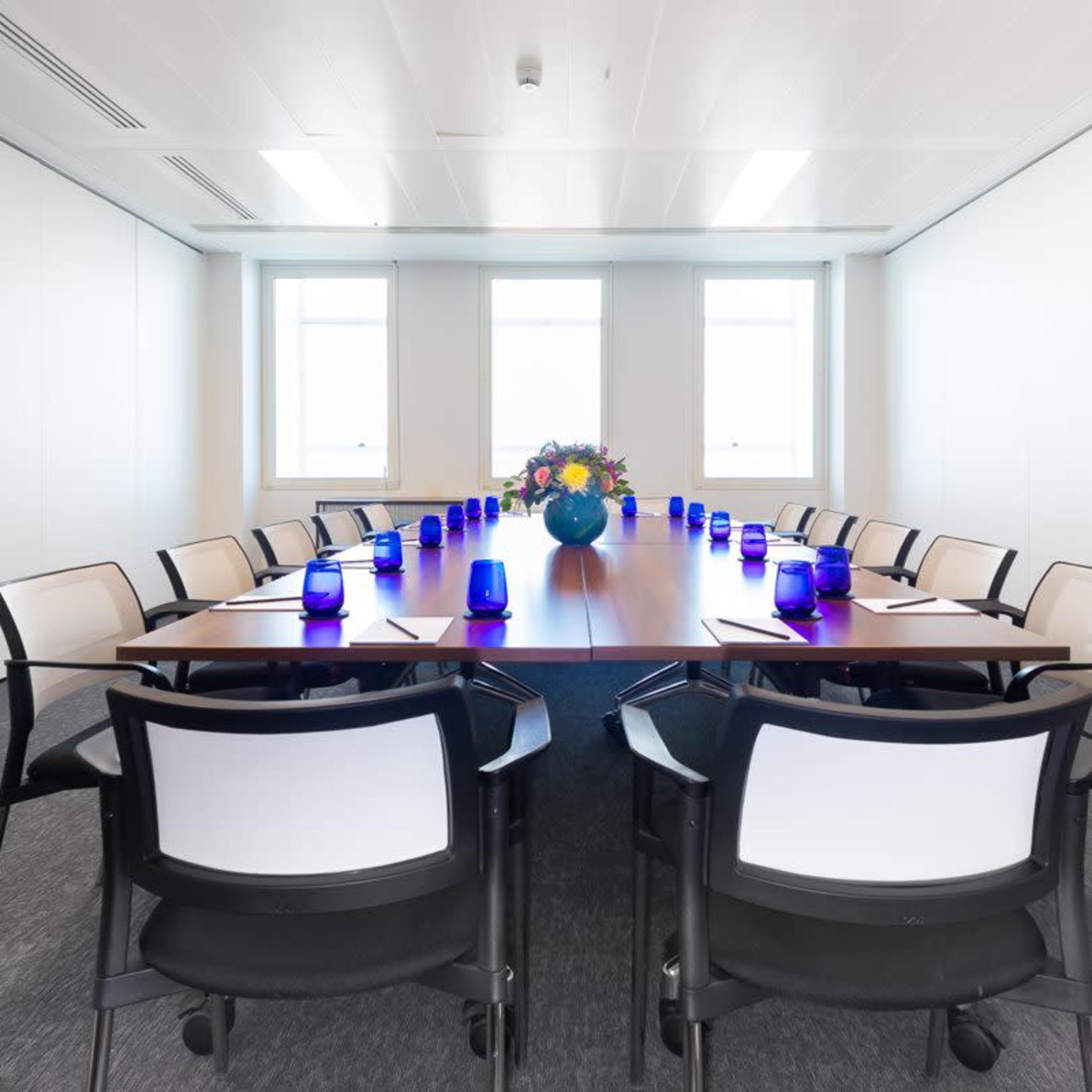Modern conference room with wooden table, ideal for corporate meetings and presentations.