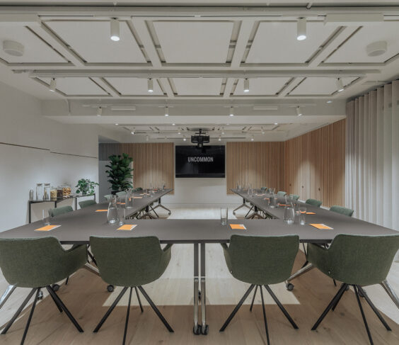 Modern meeting room with oval table and ergonomic chairs for corporate events. 