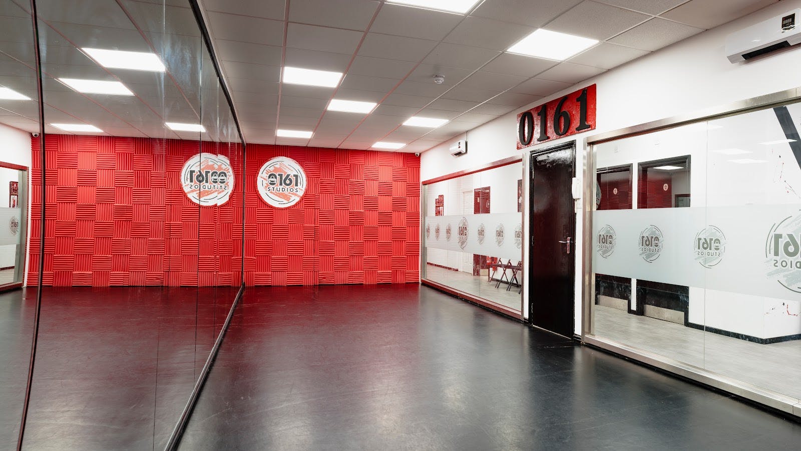 Modern event space at 0161 Studios with red accents, ideal for workshops and meetings.