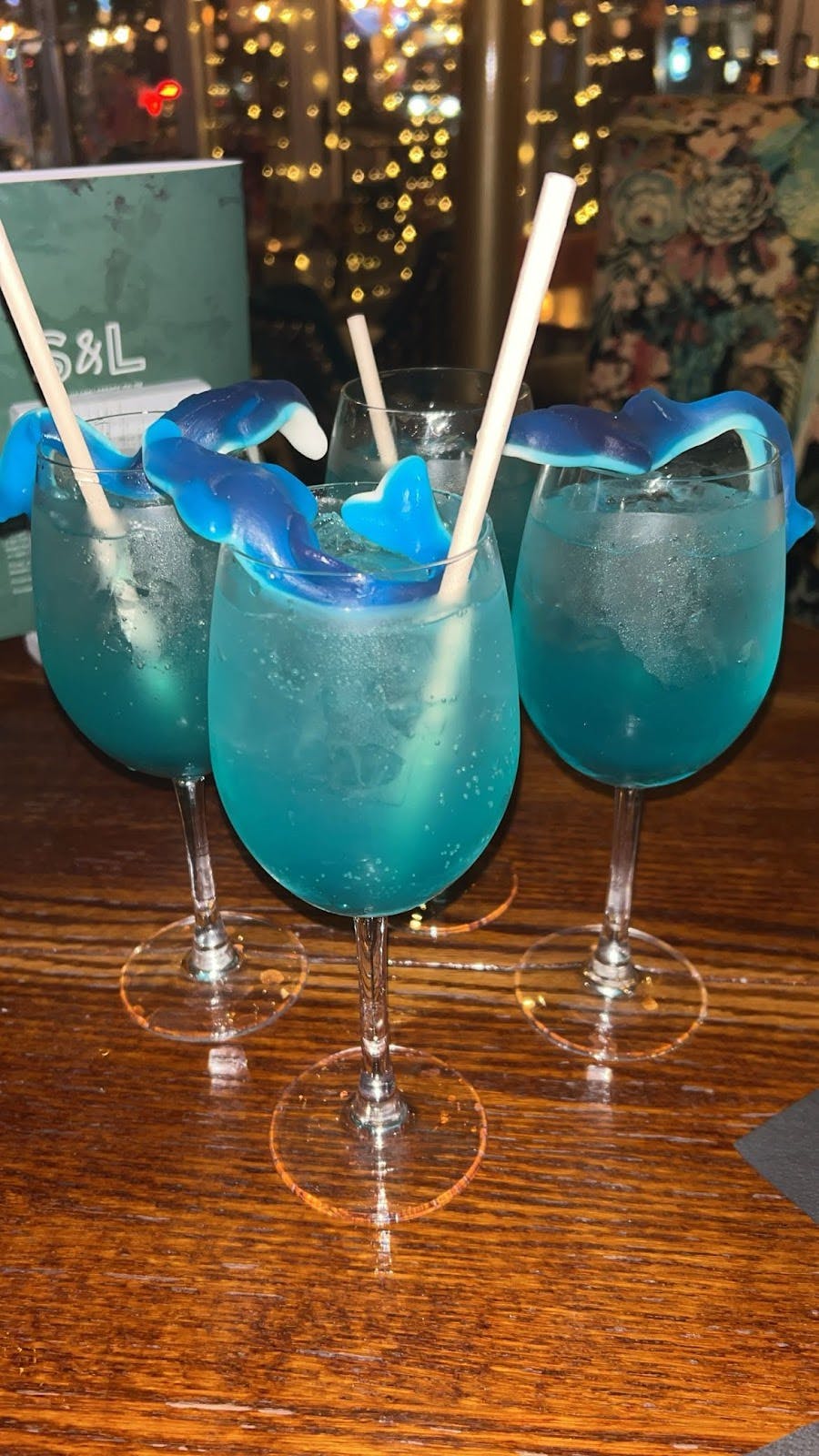 Vibrant blue cocktails with shark garnishes at Slug And Lettuce Didsbury for tropical events.