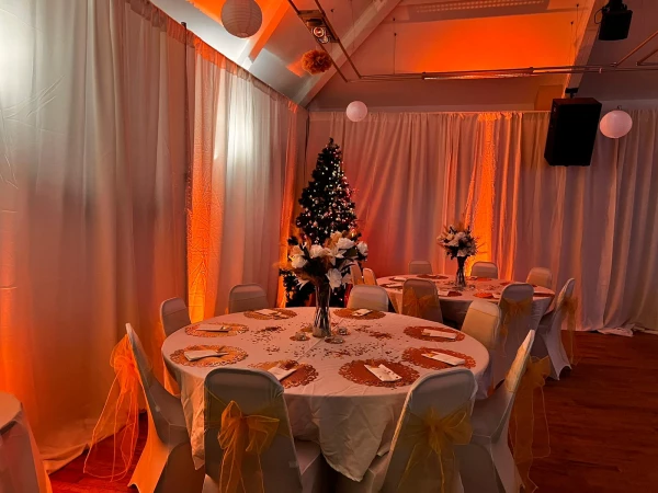 Intimate Members Lounge at Unsworth Cricket Club with cozy orange lighting for festive gatherings.