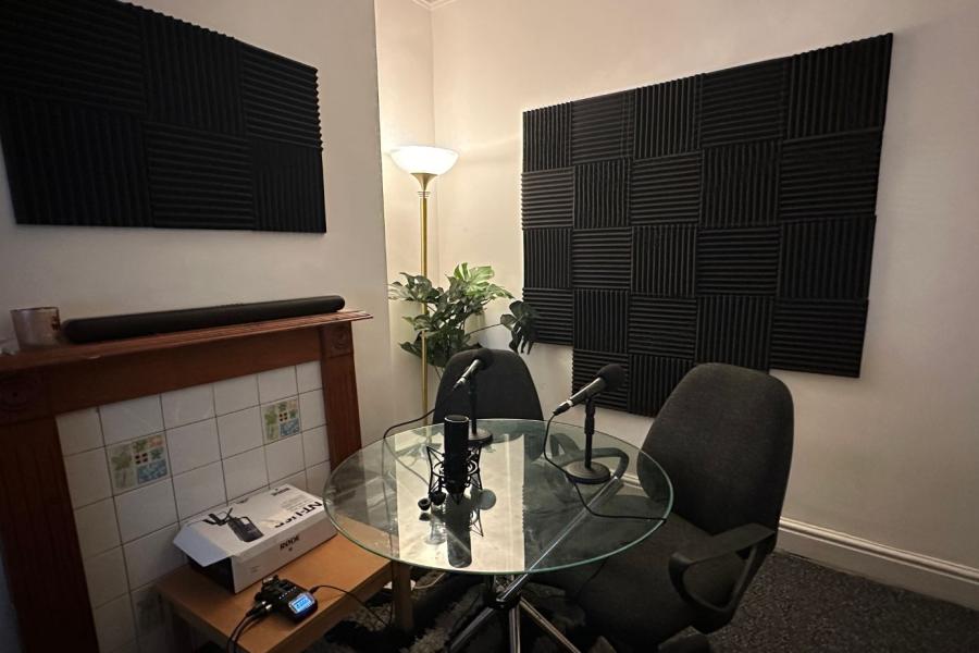 Soundproof meeting space with glass table, ideal for podcasts and interviews.