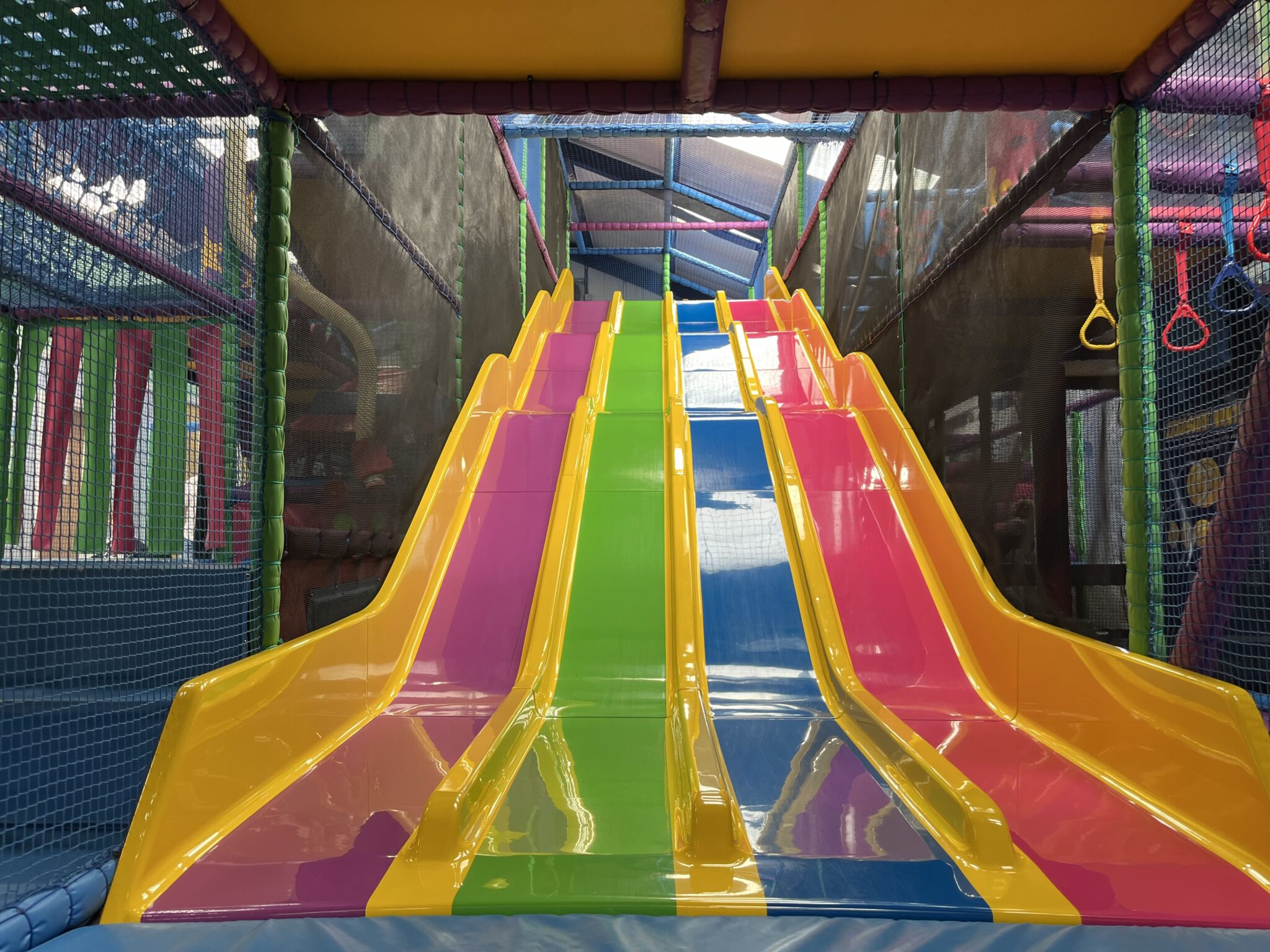 Vibrant indoor playground with multicolored slides for children's parties and family events.
