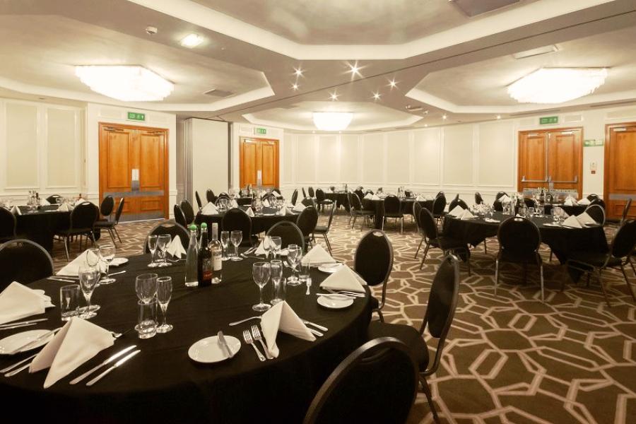 Elegant banquet room with round tables, perfect for meetings and celebrations.