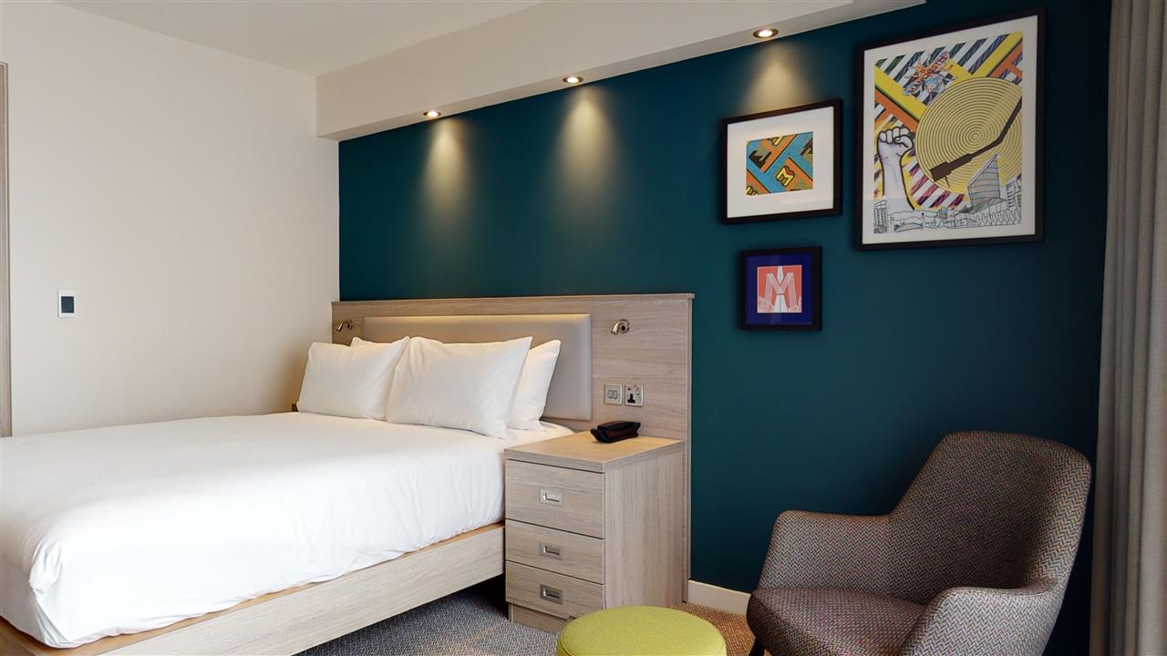 Modern hotel room in Hampton by Hilton Manchester for corporate retreats or events.