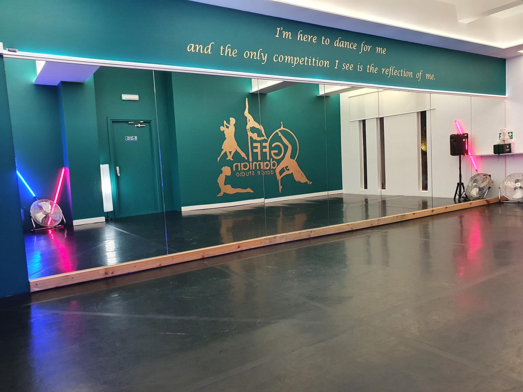 Modern dance studio with large mirror, ideal for workshops and movement classes.