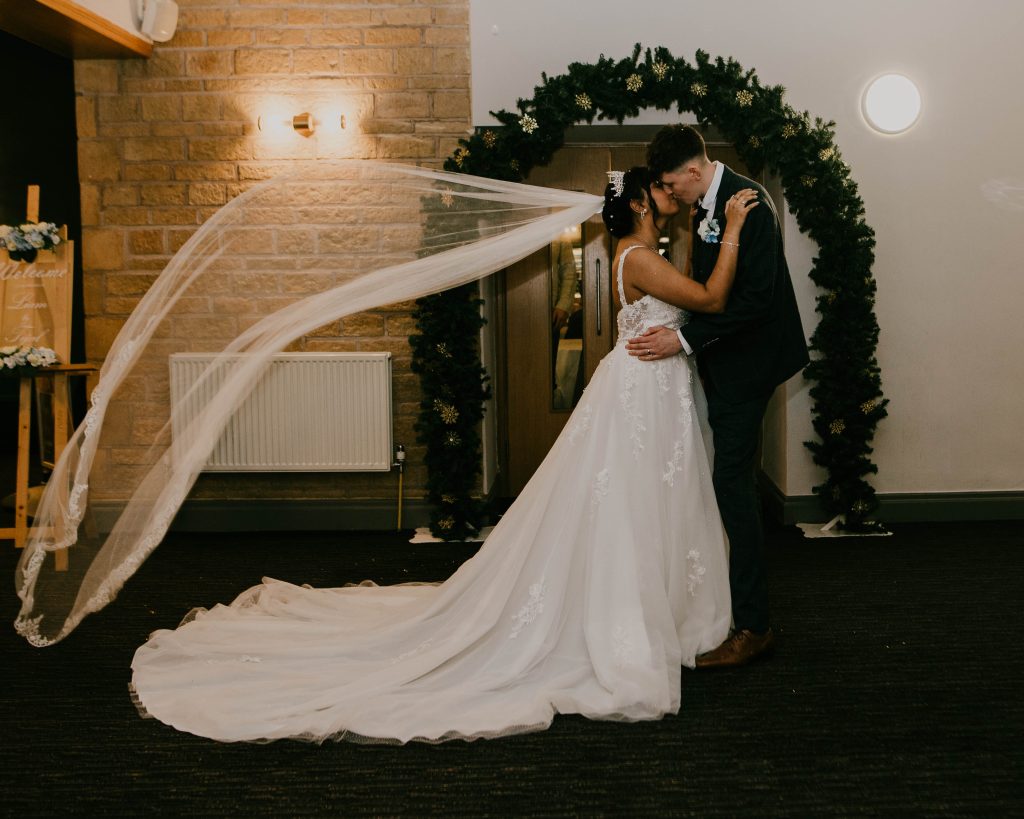Couple sharing a kiss in the elegant Mayoral Chamber at their wedding ceremony.
