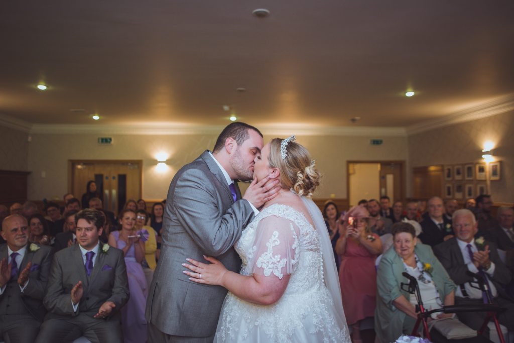 Mayoral Chamber wedding ceremony capturing couple's first kiss in elegant venue.
