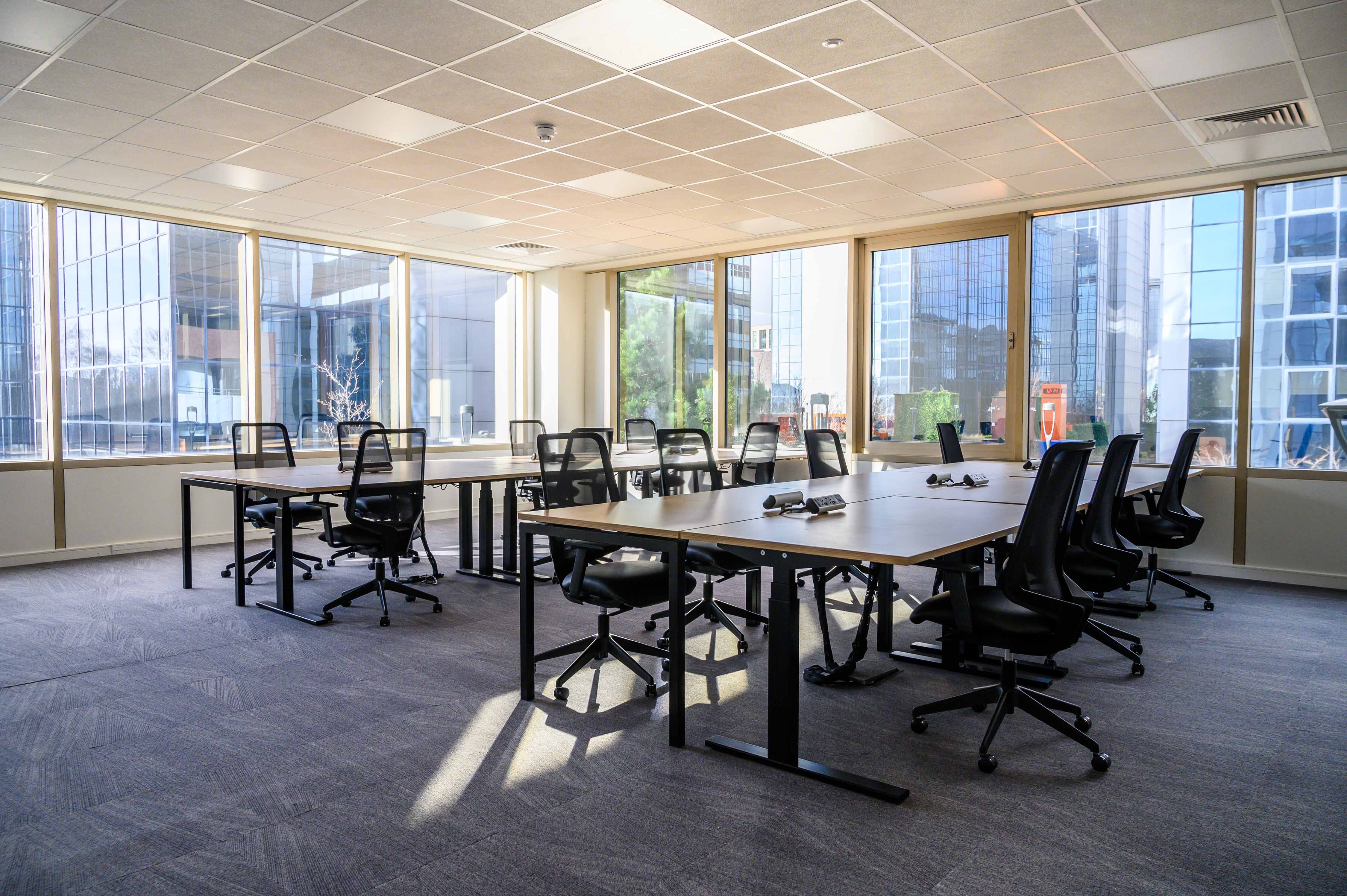 Bright modern meeting space with large windows for workshops and team meetings.