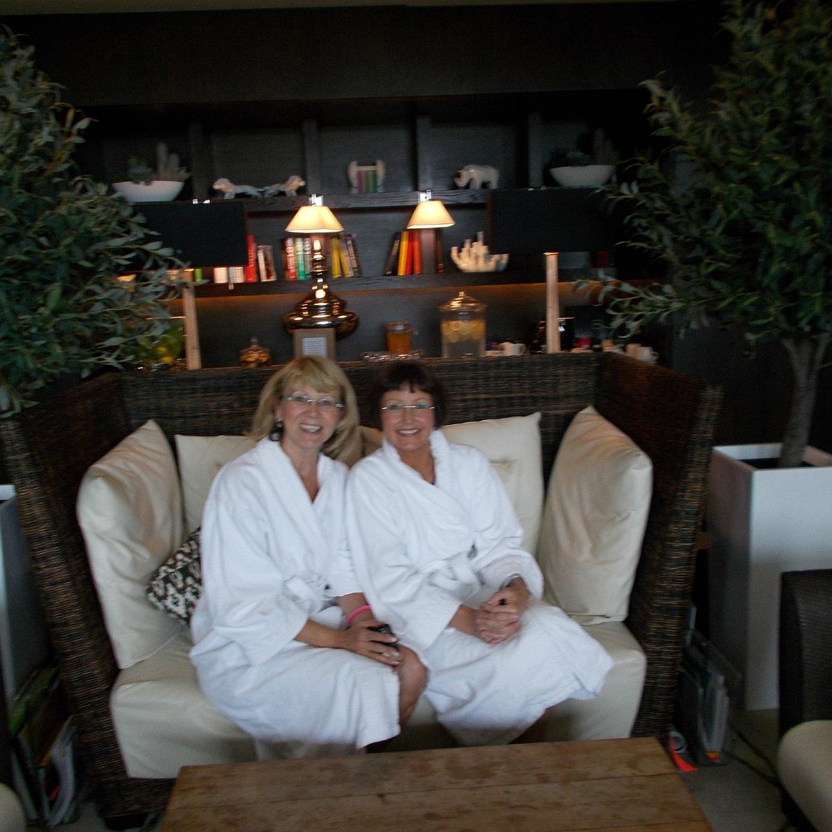 Guests in plush robes relax in the tranquil Windsor Suite lounge at a corporate wellness retreat.