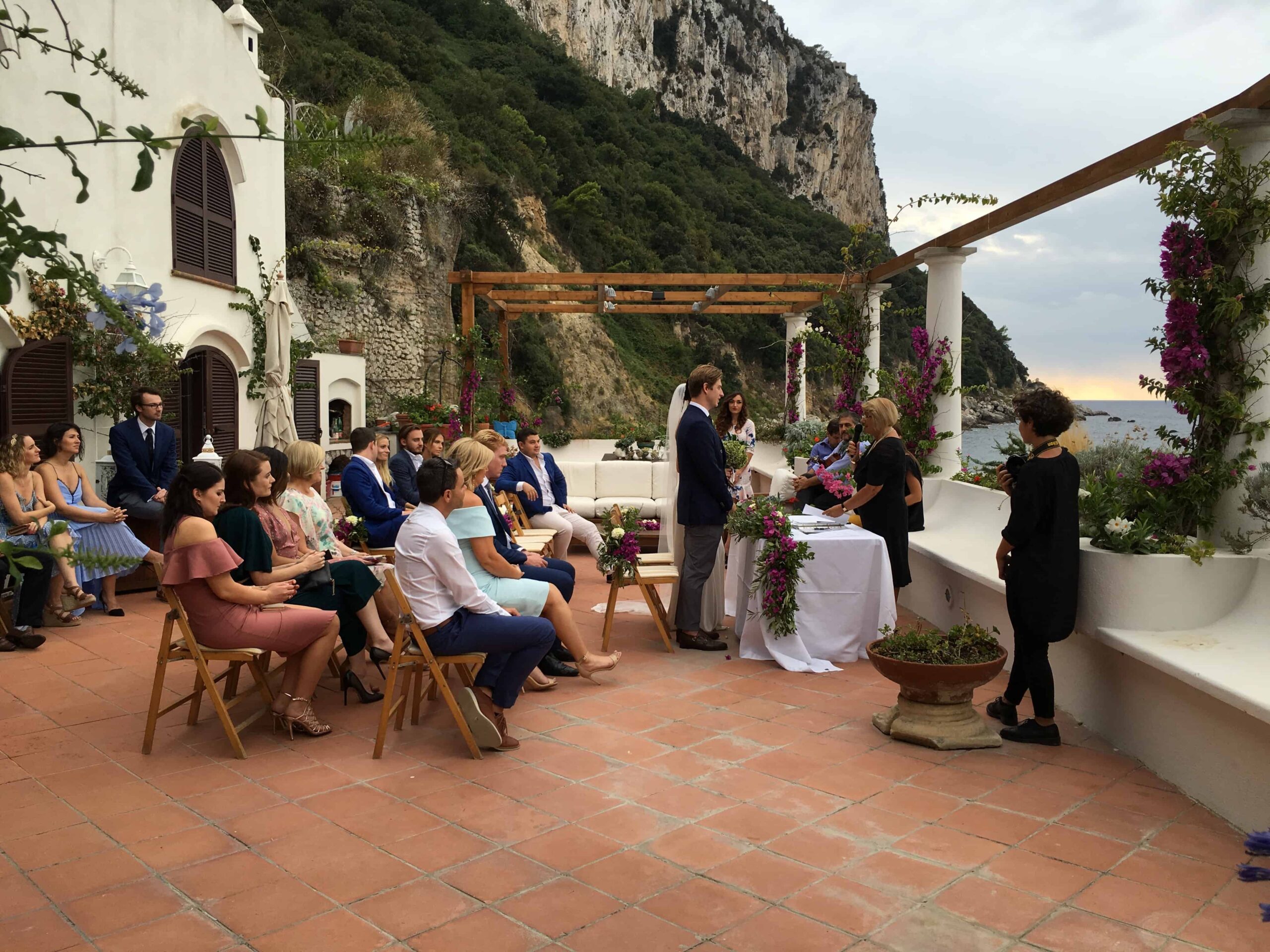 Intimate outdoor wedding at Bagni Tiberio, Capri beach club with floral decor.