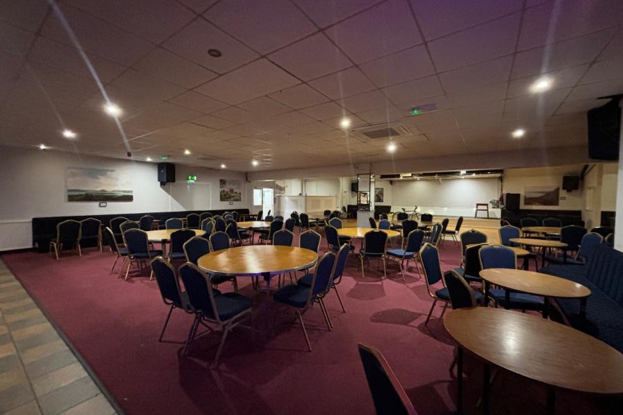 Versatile St John's Parish Centre event space with round tables, ideal for meetings and banquets.