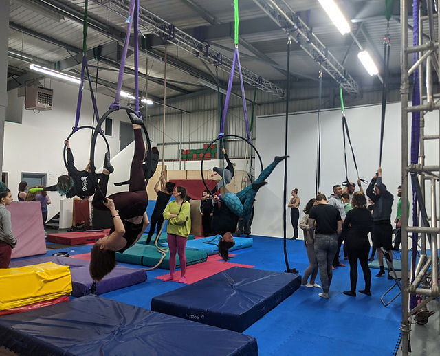 Acrobalance training in a vibrant aerial arts venue, ideal for team-building workshops.
