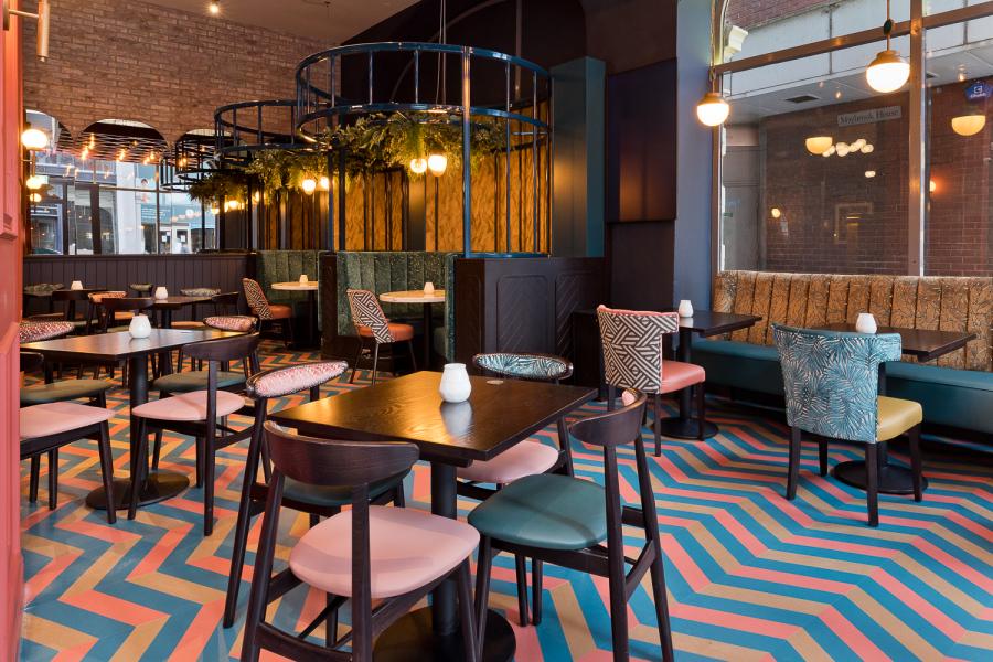 Modern dining area with chevron floor, ideal for networking events or intimate meetings.