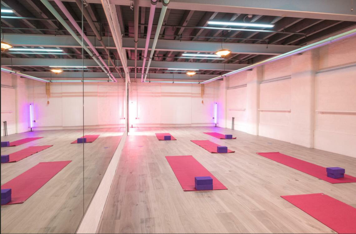 Spacious Pilates studio with pink mats, ideal for wellness retreats and mindfulness workshops.