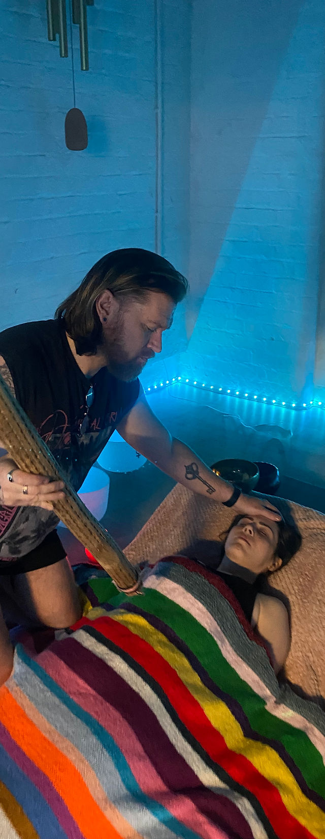 Focused individual in therapy room with blue lighting, ideal for creative workshops.