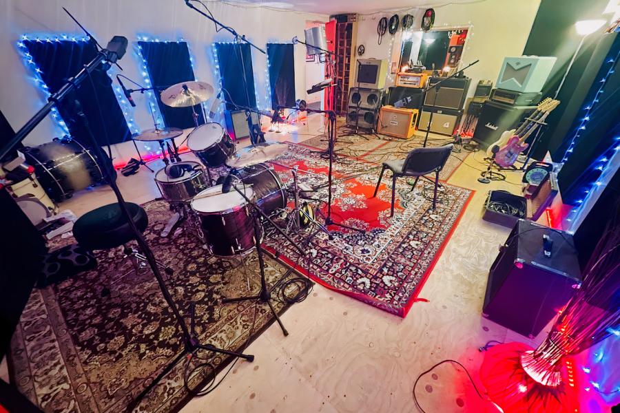 Cozy rehearsal space for live music with vibrant lighting and sound equipment.