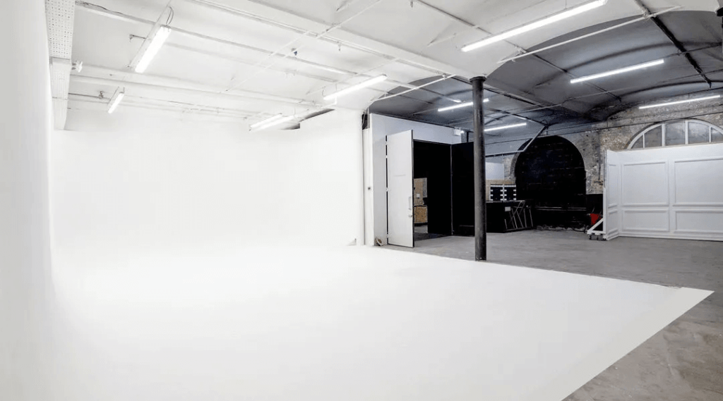 Versatile photography studio with clean white walls, perfect for events and workshops.