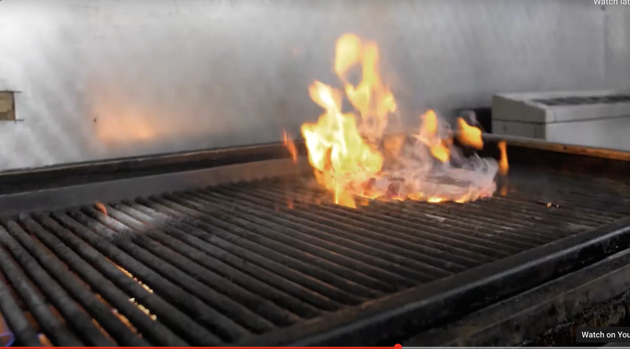 "Flaming grill at Smokin' Grill Steakhouse, perfect for catering events and outdoor parties."