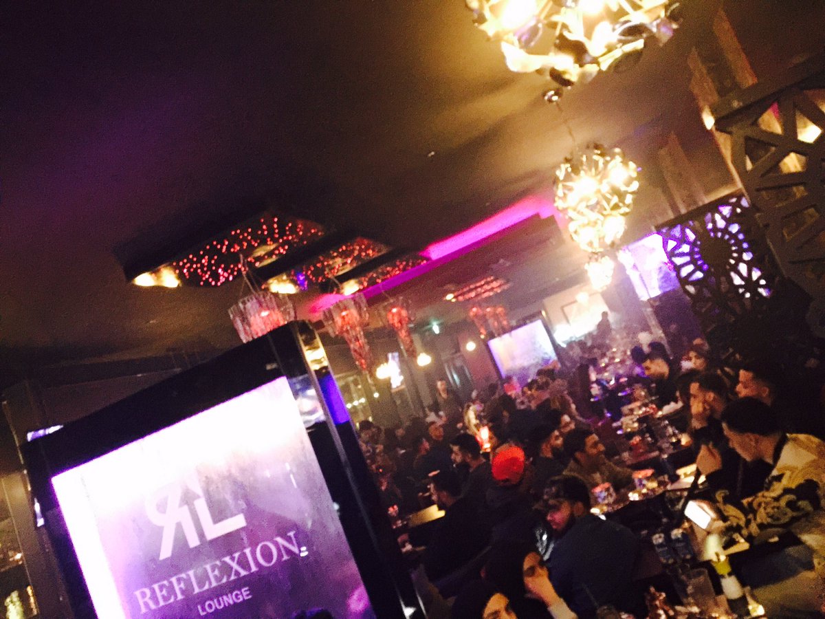 VIP networking event at Reflexion Lounge with ambient lighting and engaged guests.