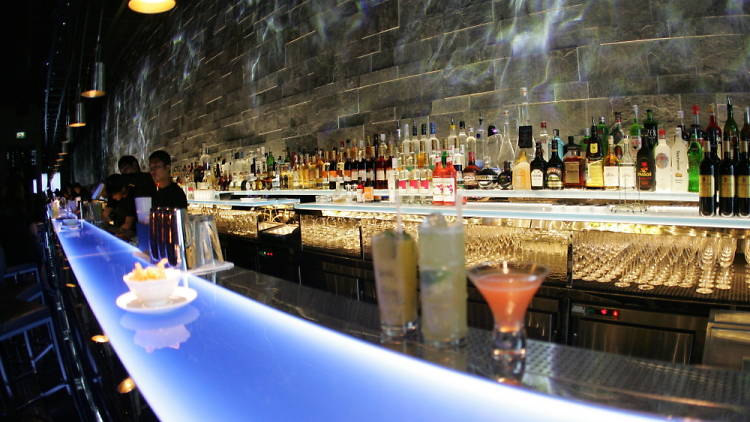 Sleek Hakkasan lounge bar with illuminated counter, ideal for networking events and cocktails.