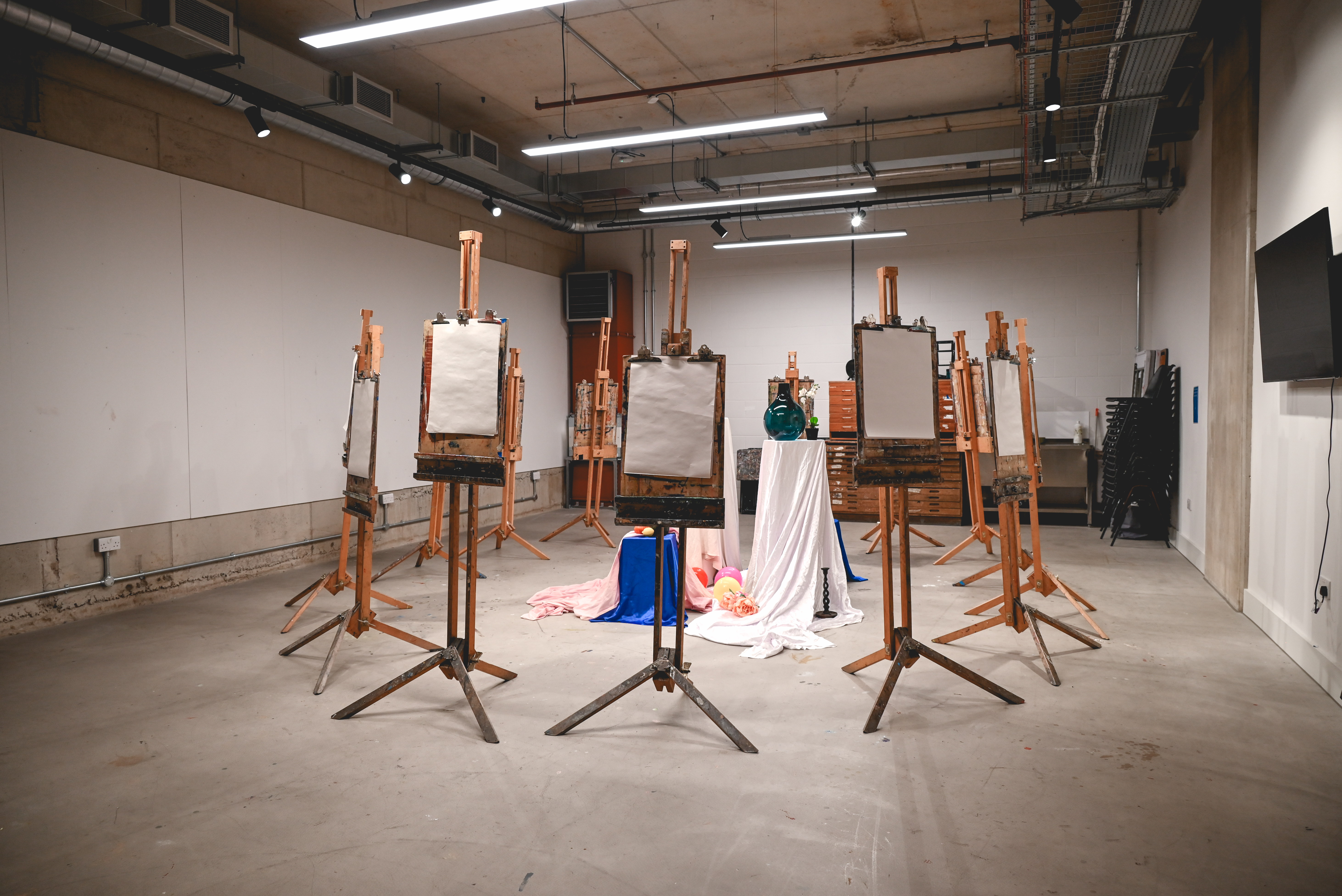 Art workshop setup in a minimalist studio with easels and blank canvases for creativity.