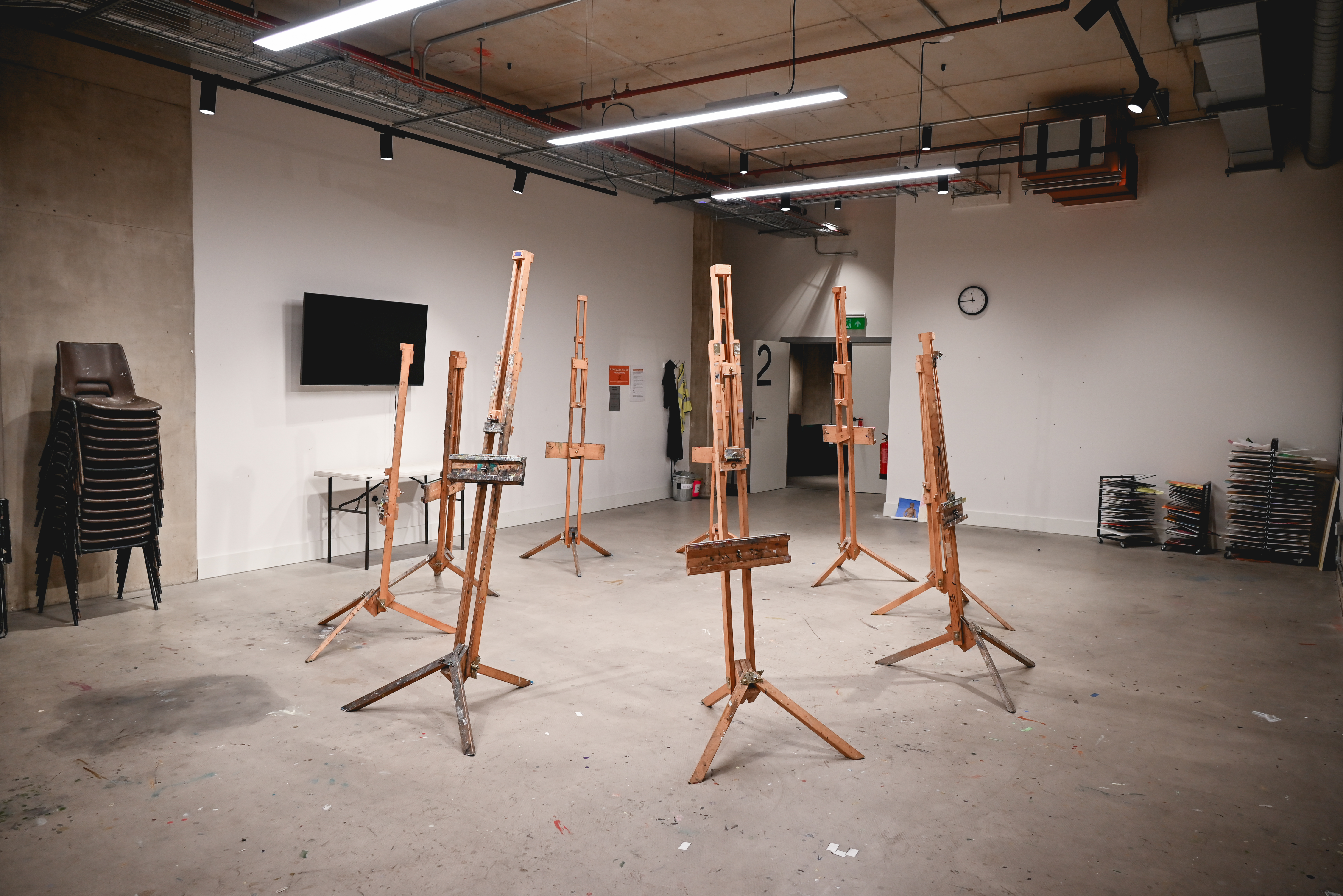 Art Academy studio with easels for creative workshops and meetings, fostering collaboration.