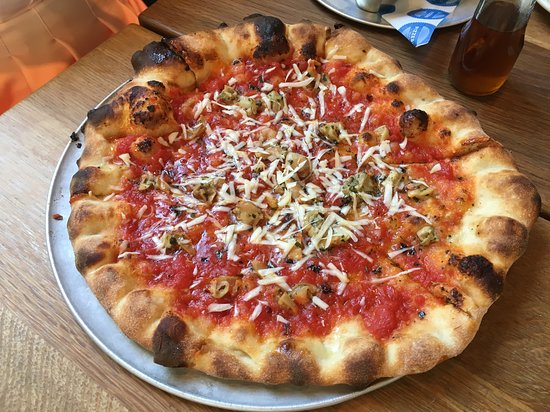 Freshly baked pizza with golden crust at Pizzeria Delfina, perfect for event catering.