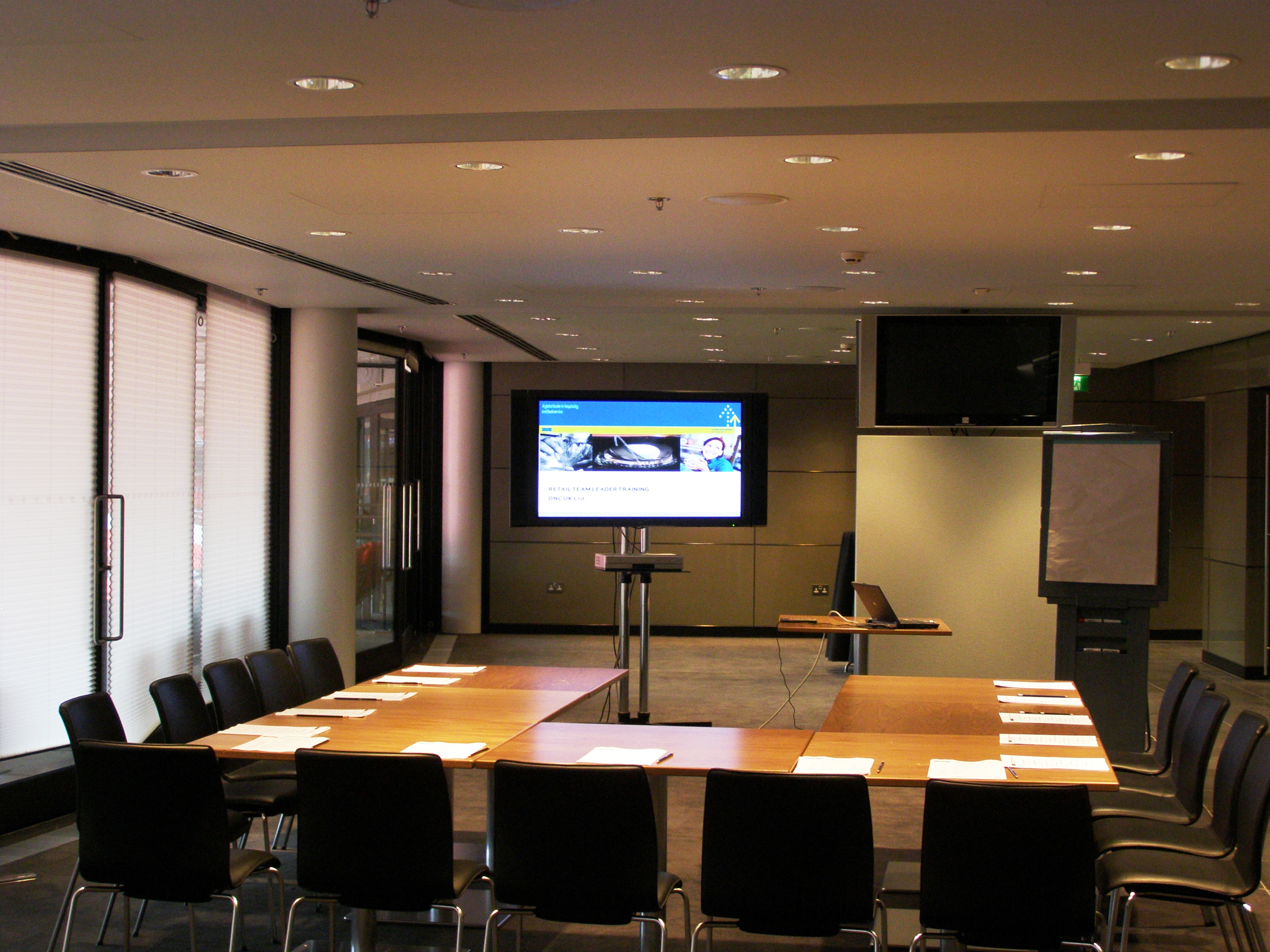 Modern meeting room at Wembley Stadium with large screen, ideal for workshops and meetings.