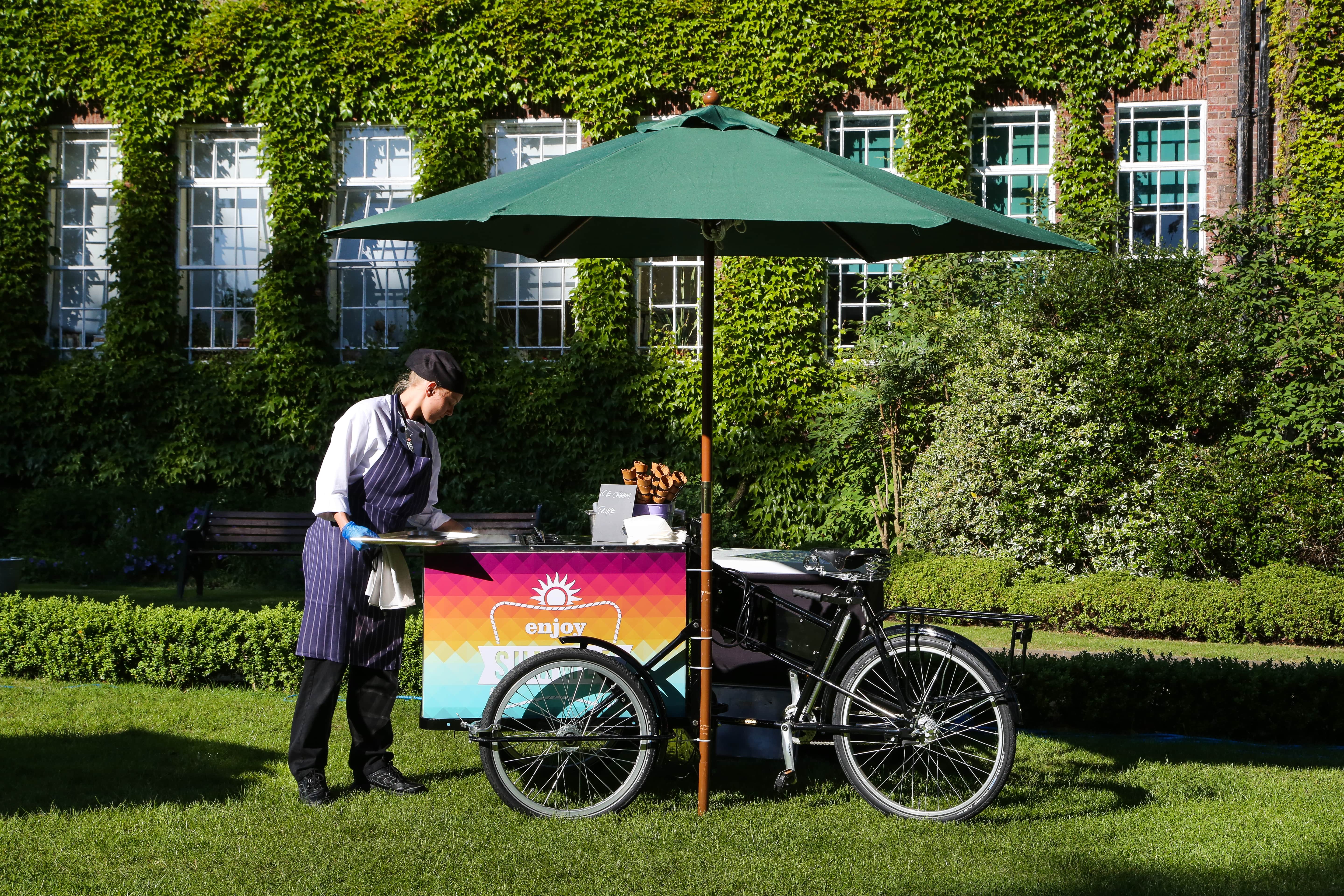 Bicycle cart under green umbrella at York Lawns, perfect for outdoor catering events.
