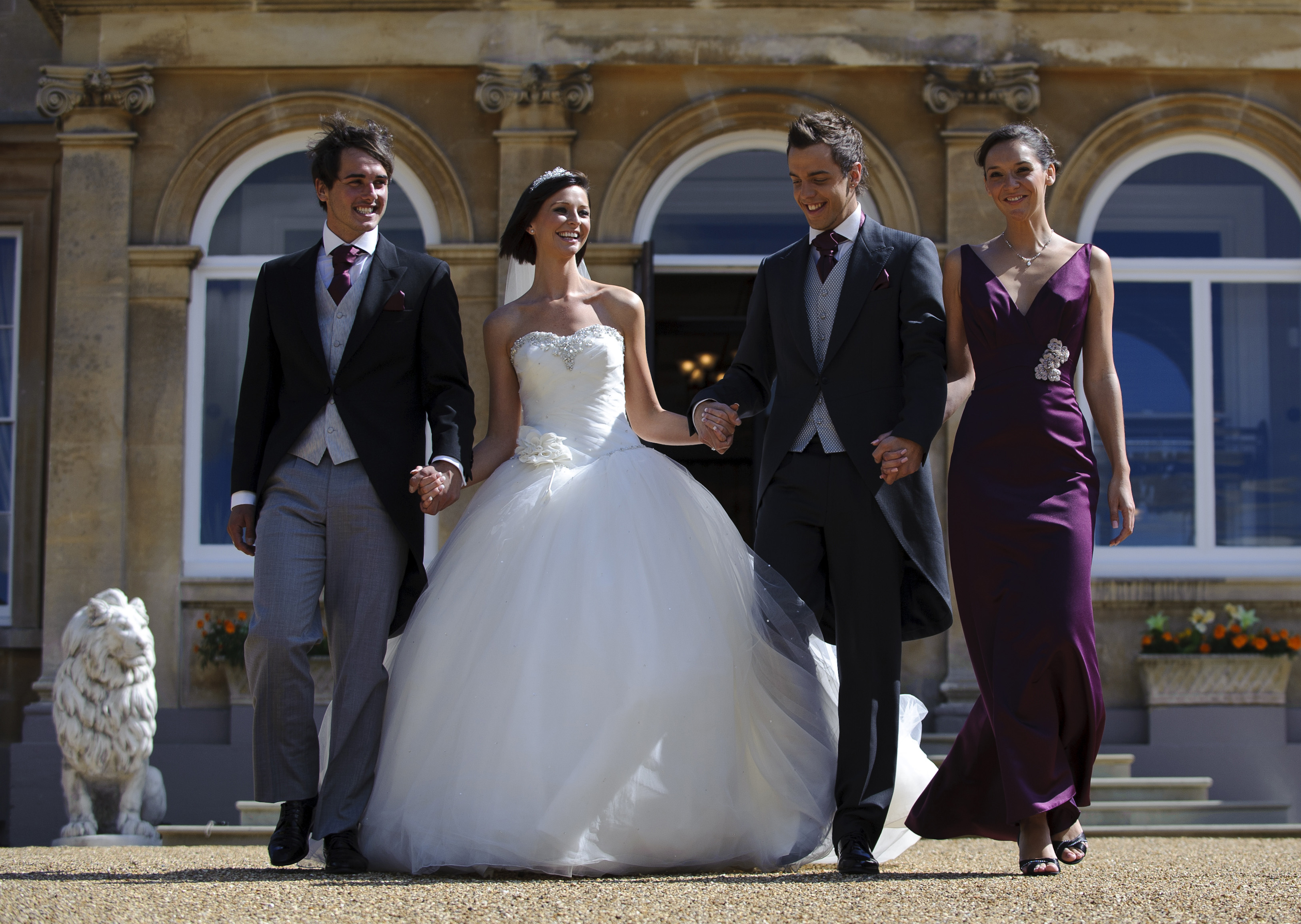 Elegant wedding party exiting Spring Grove House at West Midlands Safari Park.