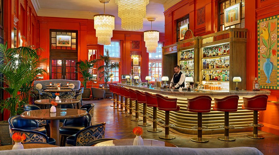 Stylish Coral Room bar with vibrant orange walls, ideal for upscale events and mixers.