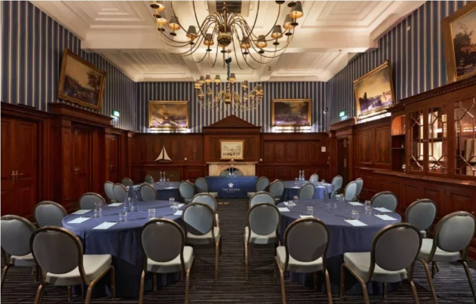 Elegant meeting room at The Regent, featuring round tables and classic decor for corporate events.