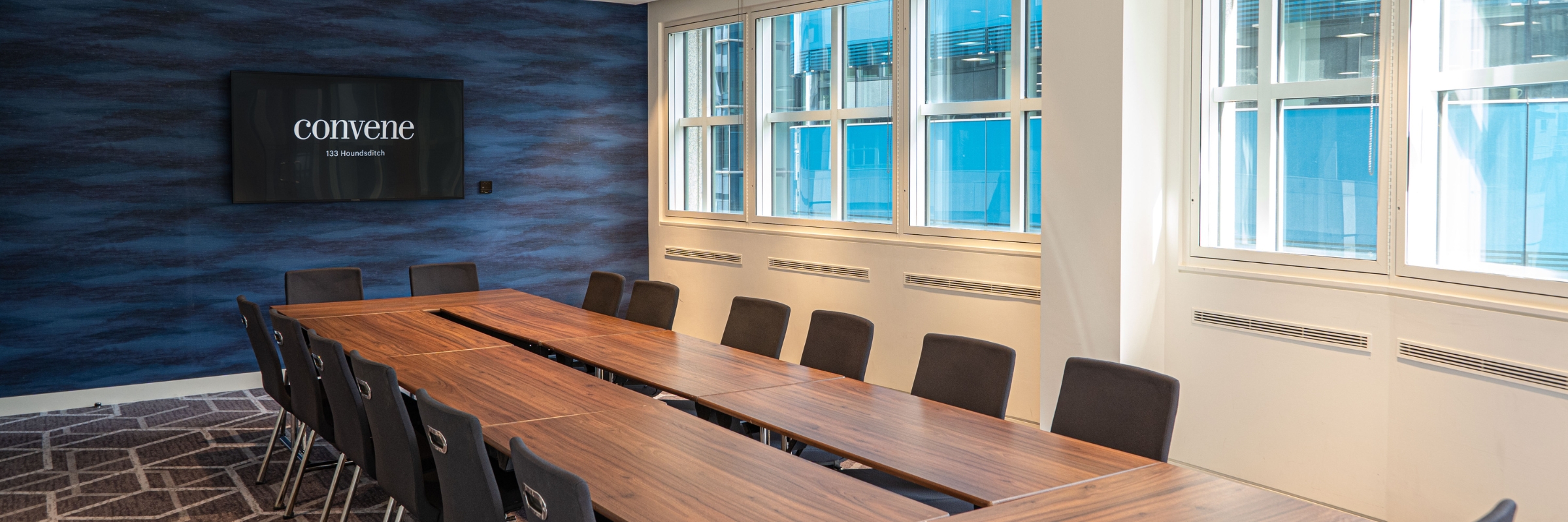 Modern conference room with large windows for events and meetings at Convene 133 Houndsditch.