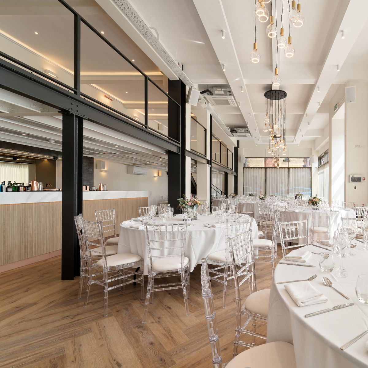 Modern event space at The Clubhouse, with elegant round tables and natural light for weddings.