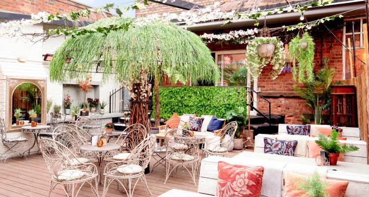 Outdoor cocktail bar with lush greenery, ideal for social gatherings and events.