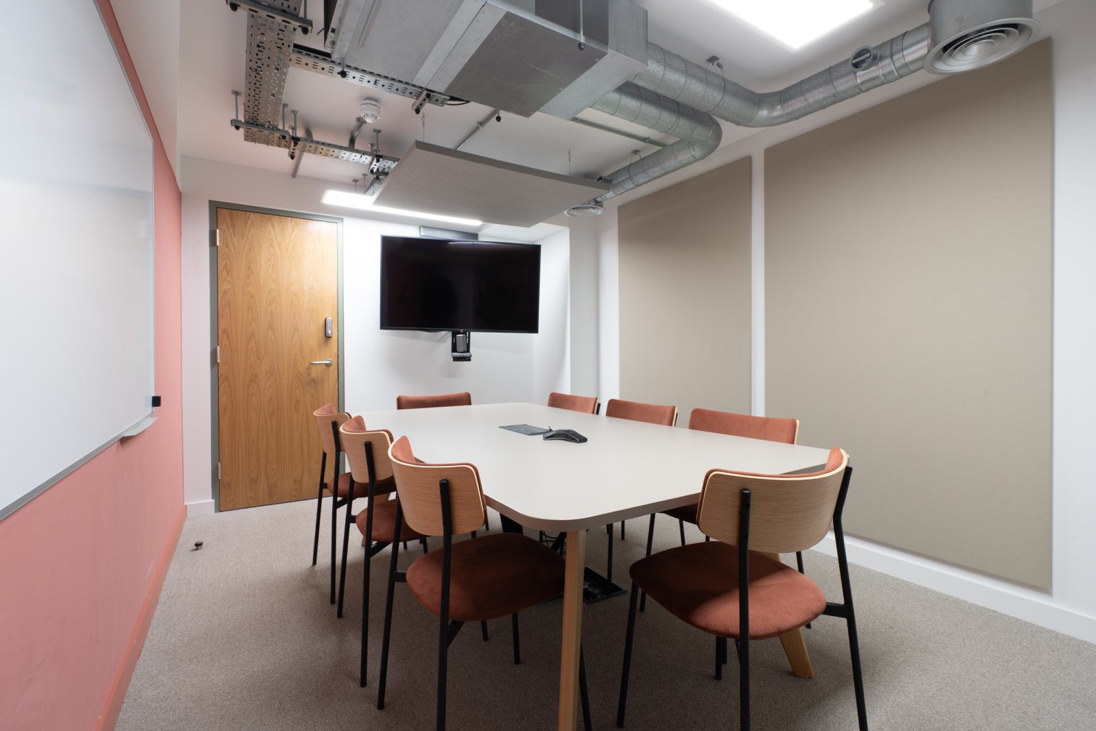Modern meeting room in Runway East Shoreditch with ergonomic chairs and large screen.