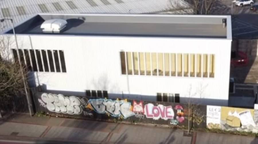 Modern event venue with large windows and street art for artistic gatherings.